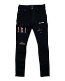 DRIPNORD black Amiri Core Logo jeans with distressed details and pink logo embroidery on the left leg.