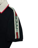 DRIPNORD black cotton polo shirt with white collar, red trim, and green/red/white stripe with 'GUCCI' logo on sleeve.