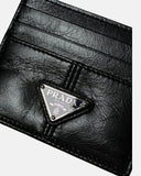 DRIPNORD black leather Prada card holder with multiple card slots and silver triangular logo.