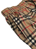 DRIPNORD Burberry Monogram Swim Shorts in classic beige, black, red, and white check pattern. Elastic waistband with drawstring.