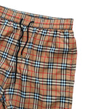 DRIPNORD Burberry Monogram Swim Shorts in tan with iconic check pattern, elastic waistband, and drawstring.