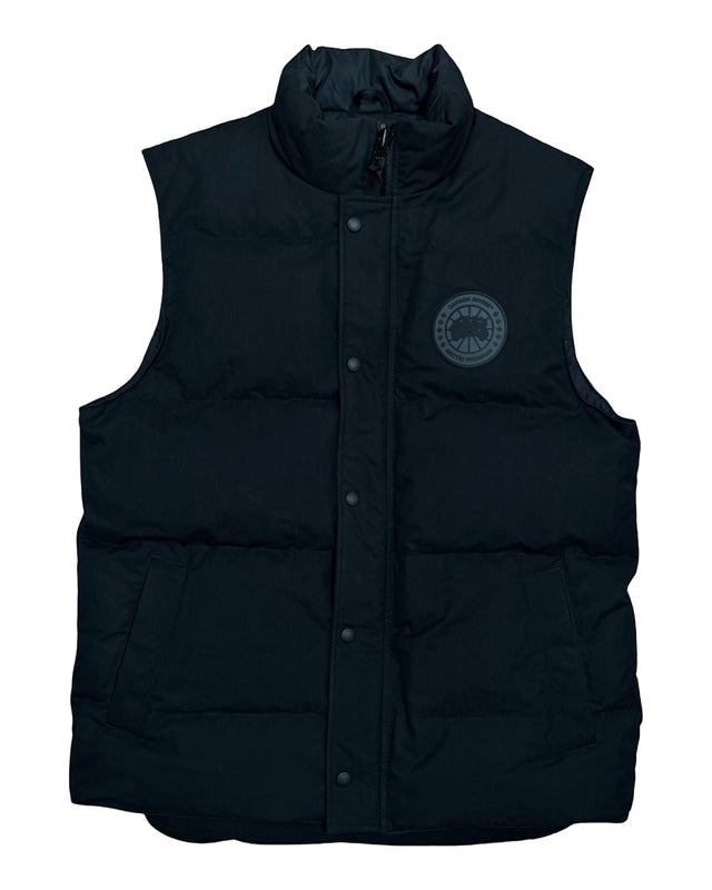 DRIPNORD Canada Goose Black Label navy puffer vest with a circular logo patch on the chest and snap button closure.