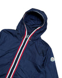 DRIPNORD navy blue Moncler Anton Giubbotto hooded jacket with red, white, and blue stripe zipper detail and Moncler logo patch.