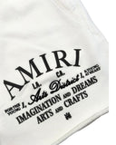 DRIPNORD white cotton Amiri Arts District shorts with black embroidered text and logo.