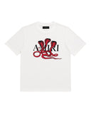 DRIPNORD white cotton t-shirt with a red cobra snake graphic and AMIRI logo. Short sleeves, crew neck.